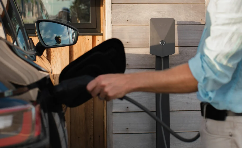 Homeowner plugging an electric vehicle into a newly installed Level 2 home EV charger by AVE Integration in North Carolina.